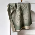 Green and beige sunflower cashmere feel scarf with tassels hanging on a shelf - 185cm / Green