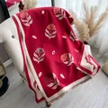 Close-up of red cashmere-feel scarf featuring floral embroidery and tassel details - Red