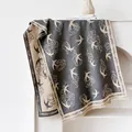 Dettaglio di sciarpa grigio beige effetto cashmere con motivi jacquard di rondini e nubi - Grigio