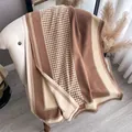 Detail shot of brown houndstooth knit scarf with tassels on white elegant chair - Khaki