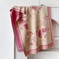 Détail d'une écharpe en imitation cachemire avec motifs fleurs papillons et franges - Rose
