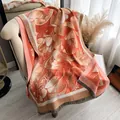 Orange and pink floral camellia cashmere shawl with grey tassels on an armchair - Yh-120 Orange - Peony / 180x65