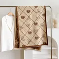 Detail of cashmere-like scarf showing heart LOVE prints and delicate tassel edges - Khaki / 185cm