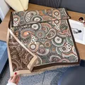 Scialle in finto cashmere con motivi paisley retrò e bordi a frange su superficie di legno - Stile con nappine e stampa paisley / Marrone