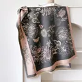 Bufanda gris oscuro con estampados florales rosas, motivos de mariposas y flecos finos - Gris