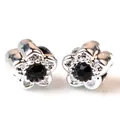 Gros plan de boucles d'oreilles fleur argentée avec cristal noir et cinq pétales - Noir