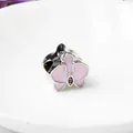 Macro shot of silver orchid charm with pink enamel petals and a small central zircon - Pink