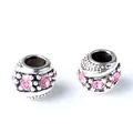 Vista macro de abalorios de plata vintage con cristallen rosas y relieve punteado - Rosa