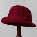 Detail showing the burgundy wool felt cloche hat with an elegant bow on a stand - M (56-58cm) / Burgundy