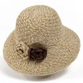 Detailed view of hand-woven straw hat with decorative dark brown floral accent - M / Beige