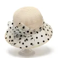 Detail van elegante beige zonnehoed met organza roos en zwart gestippelde mesh rand - M / Beige