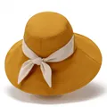 Detail view of ginger yellow sun hat featuring a wide brim and creamy white bow ribbon - M / Yellow