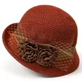 Close-up of rust red woven cloche hat featuring brown ribbon and fabric rose floral accents - M (56-58cm) / Orange