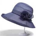 Detail van een elegante donkerblauwe zonnehoed met bloemdecoratie en mesh textuur - M / Marineblauw