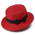 Detalle de sombrero de paja rojo con parte superior plana, cinta negra y lazo elegante - Rojo