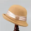 Detail of wool cloche hat with champagne satin ribbon and beaded brooch on wooden stand - M (56-58cm) / Yellow