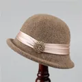 Detailed close-up of brown wool felt cloche hat with pink satin ribbon and beaded brooch - M (56-58cm) / Dark Camel
