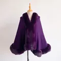Detail of dark purple wool cape featuring luxurious faux fur trim on the collar and hemline - Deep purple