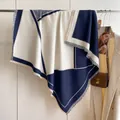 Dettaglio di sciarpa geometrica blu navy e beige con bordi con frange fini su gruccia - Blu
