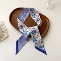 Detailed close-up of a floral silk twilly scarf with blue flower patterns on a wooden tray - 100PD-085 / 7*100cm
