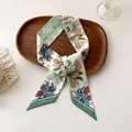 Gros plan d'un foulard en satin à motif floral avec bords vert foncé sur un plateau - 100PD-087 / 7*100cm