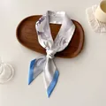 Detailed close-up of a knotted floral twilly scarf in a minimalist wooden tray - Off-White Lavender Ink Floral (N-14)