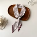 Vue détaillée d'un foulard en soie à motif cachemire sur un plateau en bois élégant - Paisley Beige Rouge Foncé (U-21)