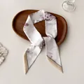 Detail shot of a slim floral twilly scarf on a wooden tray with soft lighting - Fresh White Lavender Pink Floral (O-15)