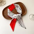 Détail d'un foulard en satin avec typographie rouge et imprimé bambou noir sur plateau - 100PD-091 / 7*100cm