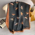 Thick faux cashmere scarf with dandelion print and orange tassel edges on an armchair - 180x65cm / Black & Orange
