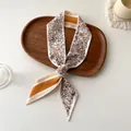 Détail d'un foulard en soie à imprimé fleurs et papillons sur un plateau en bois - Papillon Marron Blanc Rayure Orange (J-10)