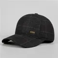 Detailansicht von dunkelgrauem Karostoff und goldenem Logo auf der Winter-Baseballkappe - Verstellbar / Schwarz