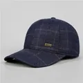 Detailansicht der dunkelblauen Woll-Baseballkappe mit Karomuster und Metallemblem - Verstellbar / Marineblau