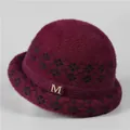 Detalle de gorro de punto granate con diseño de diamantes negros y hebilla M de cristal - M(56-58cm) / Burdeos