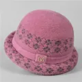 Detalle del gorro de punto rosa con patrón de rombos y logo M de metal dorado - M(56-58cm) / Malva