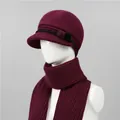 Detalle del conjunto de gorro y bufanda de punto burdeos con pompones en un maniquí - Sombreros y Bufandas / Burdeos