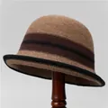 Detail of camel knitted bucket hat with brown stripes on a wooden stand - M (56-58cm) / Khaki