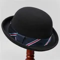 Detail of a vintage black wool bowler hat with a striped ribbon on a wooden stand - M (56-58cm) / Black