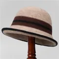 Close-up of khaki wool knit cloche hat with dark brown stripes on a wooden stand - M (56-58cm) / Beige