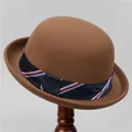 Detail of classic brown wool felt bowler hat featuring a navy ribbon on a wooden stand - M (56-58cm) / Light Coffee