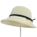 Detail van een beige geweven strohoed met een zwart lint en een kleine zijstrik - M(56-58cm) / Wit