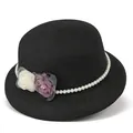 Detail van zwarte strohoed met witte parels en decoratieve ornamenten van stoffen bloemen - M / Zwart