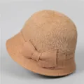 Dettaglio cappello invernale da donna con morbido peluche e fiocco in maglia - M / Cachi