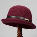 Close-up of wine red knit bucket hat featuring a black leather band and gold metal buckle - M (56-58cm) / Burgundy