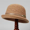 Detail of cable knit wool bucket hat with leather strap and gold buckle on a stand - M (56-58cm) / Khaki