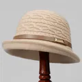 Detail of knit cloche hat with beige cable texture, brown leather strap and gold buckle - M (56-58cm) / Beige