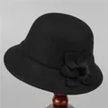 Detail van zwarte wollen cloche hoed met decoratieve 3D-bloem en zachte pompon - M / Zwart