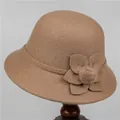 Detail van een camelkleurige wollen bucket hat met stoffen bloem en zachte bonten pompon - M / camel