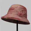 Detail of pink tie-dye bucket hat featuring a fabric bow and plush faux fur pom-pom decor - M (56-58cm) / Burgundy