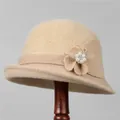 Detailed close-up of khaki knit bucket hat with pearl and rhinestone flower decoration - M / Beige